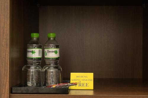 three bottles with green caps sitting on a shelf at Sen Hotel My Dinh Song Da 미딩 in Hanoi