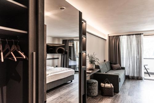 オルティゼーイにあるHotel Pineiのベッドルーム1室(ベッド1台付)、リビングルームが備わります。