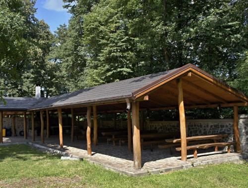 a pavilion with tables and benches in a park at Hotel Biele Studničky Dargov in Dargov