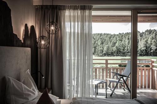 オルティゼーイにあるHotel Pineiのベッドルーム1室(ベッド1台付)が備わります。デッキの景色を望めます。