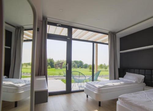 a bedroom with two beds and a large glass window at Bungalows Kingsland in Ineu