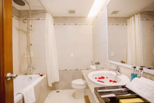 a bathroom with a sink and a toilet and a tub at Minh Toan Athena Hotel in Danang