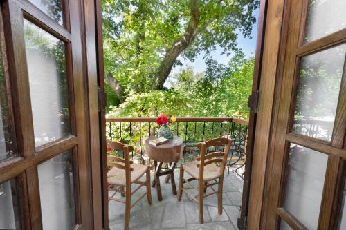 a patio with a table and chairs and a balcony at Palios Stathmos in Miléai