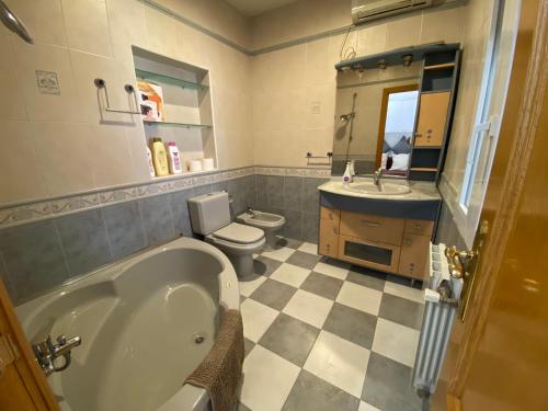 y baño con bañera, aseo y lavamanos. en Casa Nala: Warner, Madrid y Toledo a un paso, en San Martín de la Vega