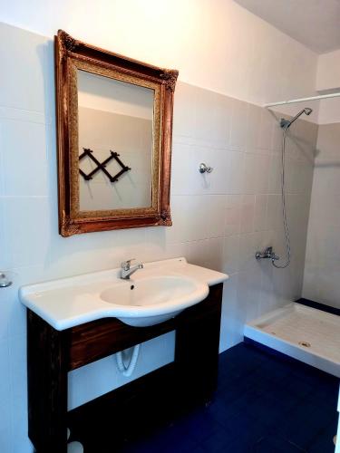 a bathroom with a sink and a mirror and a tub at Amphora Guesthouse in Himare
