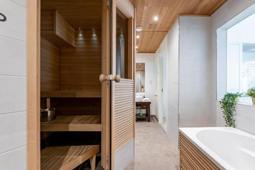 ein Badezimmer mit einer Badewanne und einem Waschbecken in der Unterkunft 2ndhomes Tampere "Penthouse" Apartment - Private Sauna & Terrace in Tampere