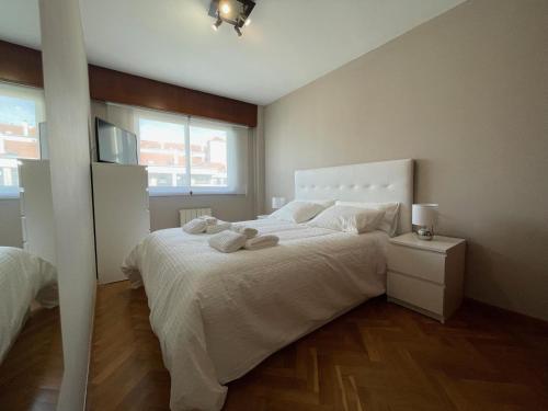 ein Schlafzimmer mit einem großen weißen Bett und einem Fenster in der Unterkunft housingcoruña ROSALES in A Coruña