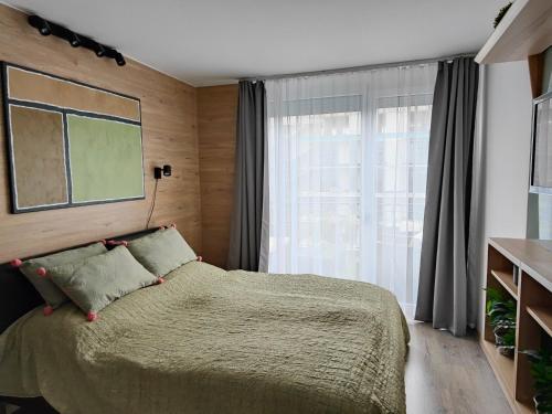 een slaapkamer met een bed en een groot raam bij Beachfront Paradise Ezüst Panoráma lakeview apartment with panoramic terrace in Siófok