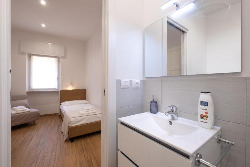 a white bathroom with a sink and a bedroom at barbara apartment verona in Verona