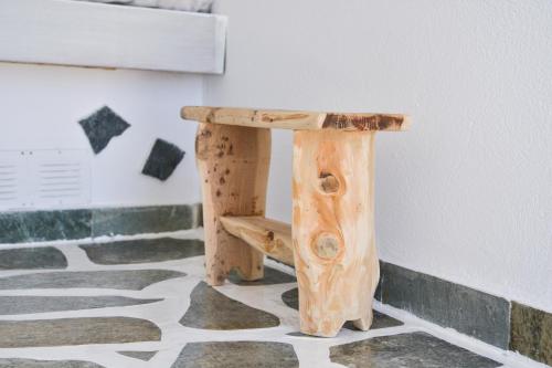 a wooden bench sitting on top of a floor at Fisherman's Syrma House in Pachaina
