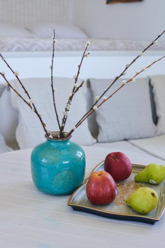 a blue vase with branches and apples on a table at Fisherman's Syrma House in Pachaina