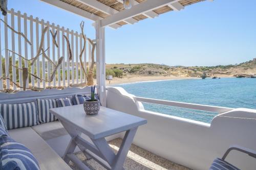 a table on a balcony with a view of the ocean at Fisherman's Syrma House in Pachaina