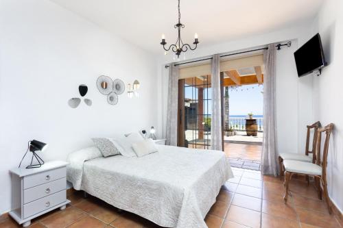 um quarto branco com uma cama e uma cadeira em Home2Book Garachico Ocean View em Las Cruces