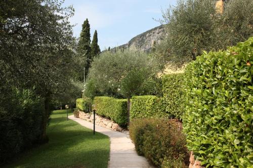 a garden with bushes and a walk way at Appartamenti Pratone in Garda