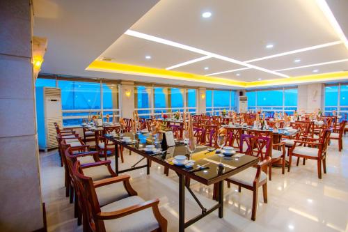 ダナンにあるMinh Toan Athena Hotelのテーブルと椅子、窓のある宴会場