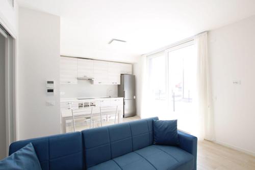 een blauwe bank in een woonkamer met een keuken bij Gray Palace - Home Immobiliare Jesolo in Lido di Jesolo