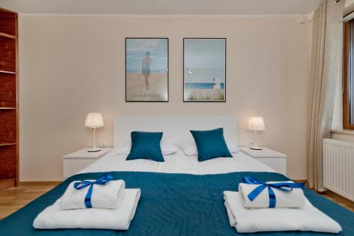 a bedroom with a large bed with blue pillows at BlueApart Apartamenty Na Klifie in Władysławowo