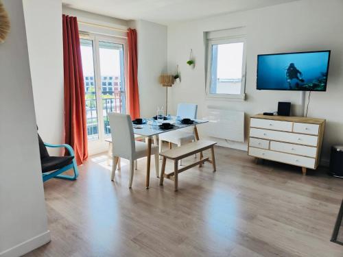 ein Esszimmer mit einem Tisch, Stühlen und einem TV in der Unterkunft Suite Villanova Near Disneyland Paris in Chessy