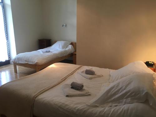 two beds in a room with towels on them at Hotel MAZIN in La Motte-en-Beauges