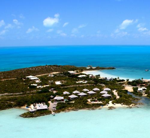 an island with white umbrellas in the ocean at Neptune Villas in Five Cays Settlement