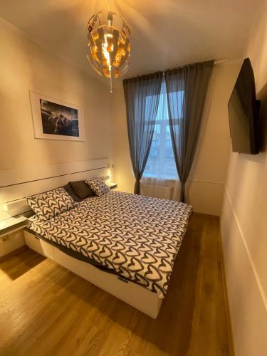 sypialnia z łóżkiem, oknem i żyrandolem w obiekcie HappyDog Lounge w Rydze