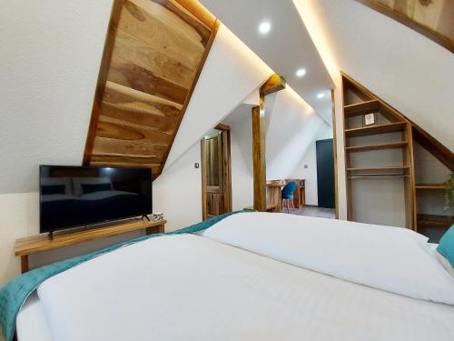 a bedroom with a bed and a flat screen tv at Etno Boutique in Plitvička Jezera
