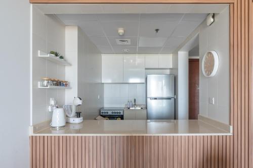 a kitchen with a refrigerator in the middle of it at SeaBreeze Apartment - Beachfront & Sea View Al Hamra in Ras al Khaimah