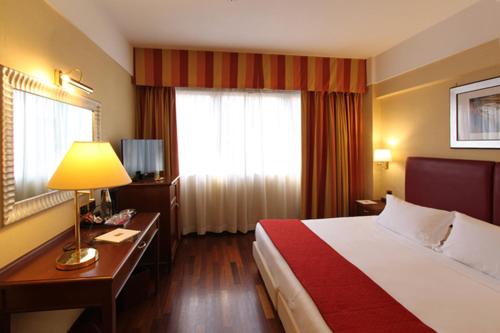 Ein Bett oder Betten in einem Zimmer der Unterkunft iH Hotels Roma Cicerone