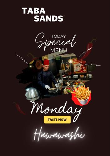 a man cooking in a kitchen with a happy mondaynesday poster at Taba Sands Hotel & Casino in Taba