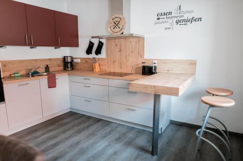 a kitchen with white cabinets and a wooden counter top at Ferienwohnungen Finkengrund in Büren