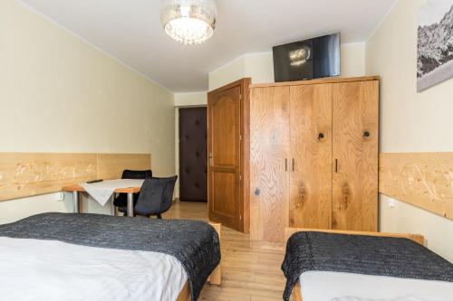 a hotel room with two beds and a desk at Leśny Dwór in Murzasichle