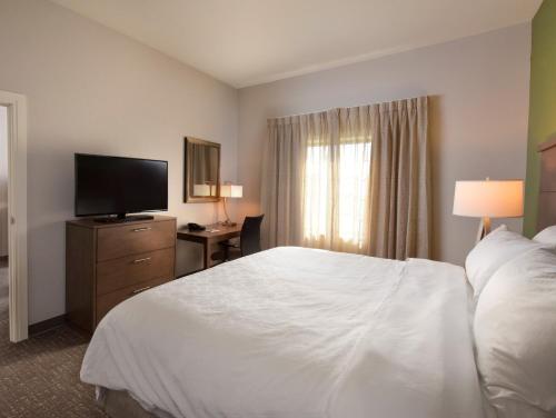 a hotel room with a bed and a flat screen tv at Staybridge Suites - Wisconsin Dells - Lake Delton by IHG in Wisconsin Dells