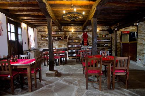 een restaurant met houten tafels en stoelen in een kamer bij Dedovite Kashti in Stefanovo