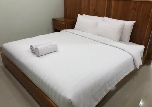 Una cama blanca con un rollo de papel higiénico. en OmahKoe Homes, en Batu