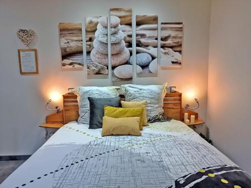 a bedroom with a bed with four paintings on the wall at L'Escale Sud Gironde - Séjour en amoureux avec jacuzzi privatif - Piscine - Massage Traiteur & Brunch possibles in Pompéjac