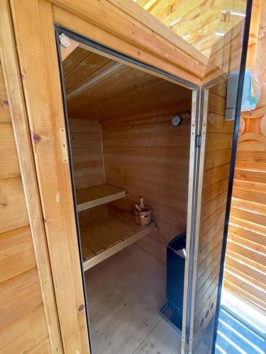 a sauna with a glass door in a wooden cabin at Sobe App Moj Hir bed and breakfast in Jastrebarsko