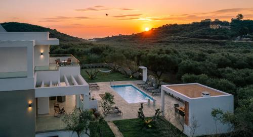 a villa with a swimming pool in front of a sunset at Valentino Luxury Villa in Plános