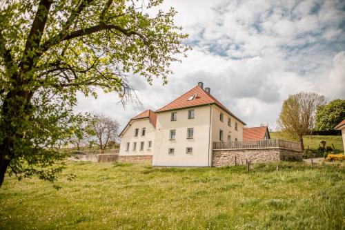 a white house in a field with a tree at Ferienwohnungen Finkengrund in Büren