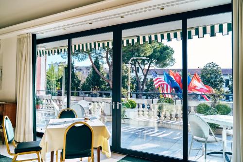 a room with a table and chairs and a large window at Ambassador Palace Hotel in Udine