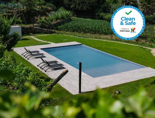 a swimming pool in a yard with a sign at Casa da Ponte Velha in Termas de Sao Pedro do Sul