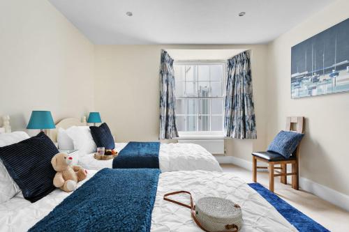 a bedroom with two beds and a teddy bear on the bed at Sovereign House - Close to harbour with parking in Torquay