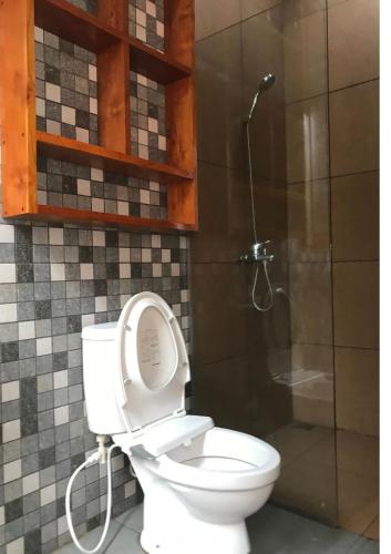 un baño con inodoro y ducha en OmahKoe Homes, en Batu