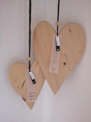 two wooden hearts hanging on a wall at Vornbichlhof in Fieberbrunn