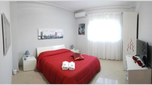 a bedroom with a red bed with two white shoes on it at Catania Suite Home in Catania