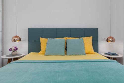 a bed with a blue headboard and yellow pillows at Apartments Paloc - Yellow in Bol