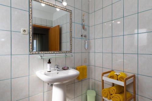 a bathroom with a sink and a mirror at Apartments Paloc - Yellow in Bol