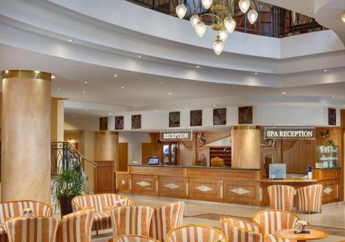 a lobby with a restaurant with chairs and a counter at Ensana Butterfly in Mariánské Lázně