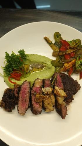 a plate of food with meat and vegetables on a table at Niyati - Boutique Stay in Cochin
