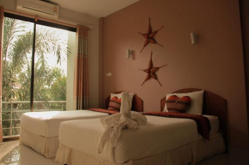 two beds in a bedroom with stars on the wall at Thai Lao Resort and Spa โรงแรมไทลาว รีสอร์ท แอนด์ สปา in Nakhon Phanom