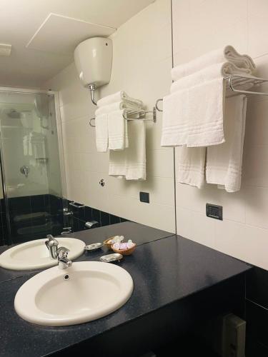 a bathroom with two sinks and a mirror and towels at Locanda del Glicine in Campagnatico
